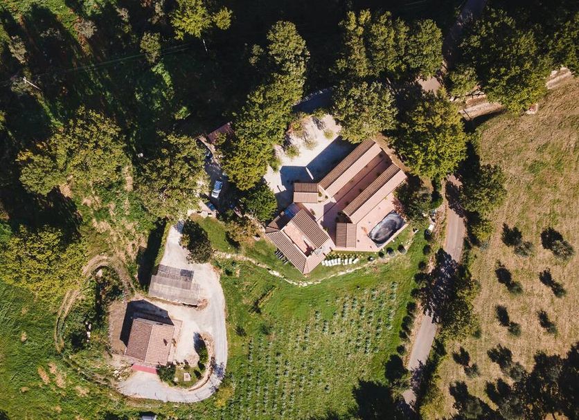 Aerial view of Agriturismo La Meria in Semproniano surrounded by trees and fields