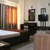 Hotel Maiden Residency Ghāziābād guest room with bed, TV, curtains, and seating area
