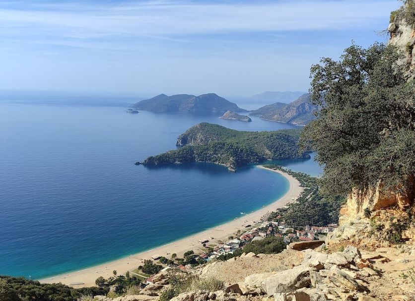 Salonika Suites in Ölüdeniz overlooking a turquoise bay, sandy beach, and mountain views