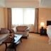 Qilu International Hotel Harbin room with bed, sofa seating area, and large window