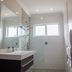 Sea Breeze Guesthouse Swakopmund bathroom with walk-in shower, vanity, white tile and mosaic floor