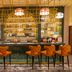 DoubleTree Suites by Hilton Bengaluru Outer Ring Road bar with gold shelving and orange bar stools