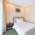 Long Ge Hotel in Beijing guest room with a single bed, bedside table, and framed wall art