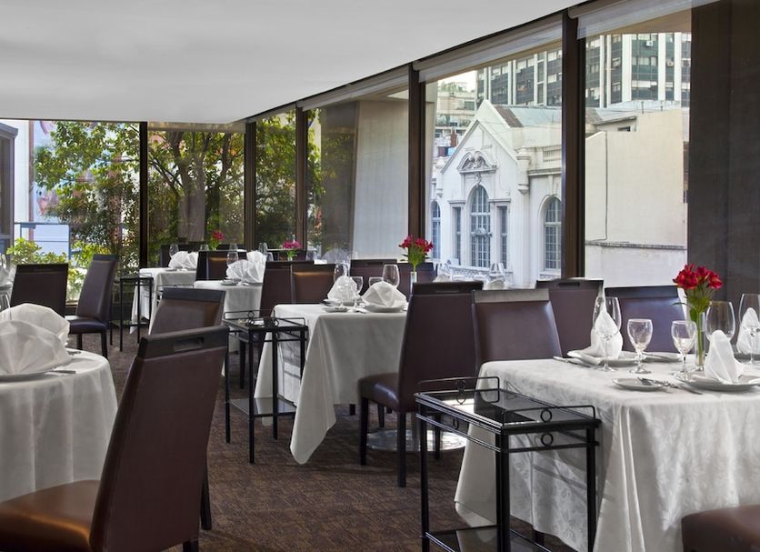 Libertador Hotel Buenos Aires dining room with set tables and large windows overlooking city buildings