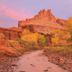 High Desert Inn in Salina with a desert trail, red rock cliffs, and autumn trees at sunset