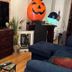 The Macaw Guesthouse in New York guest room with TV, dresser and Halloween pumpkin decor