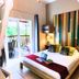 Hotel Les Bougainvilliers, Saint-Paul: bright guest room with king bed, colorful accent wall and balcony