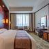 Li An Hotel Hohhot guest room with king bed, desk, TV, and large window seating area