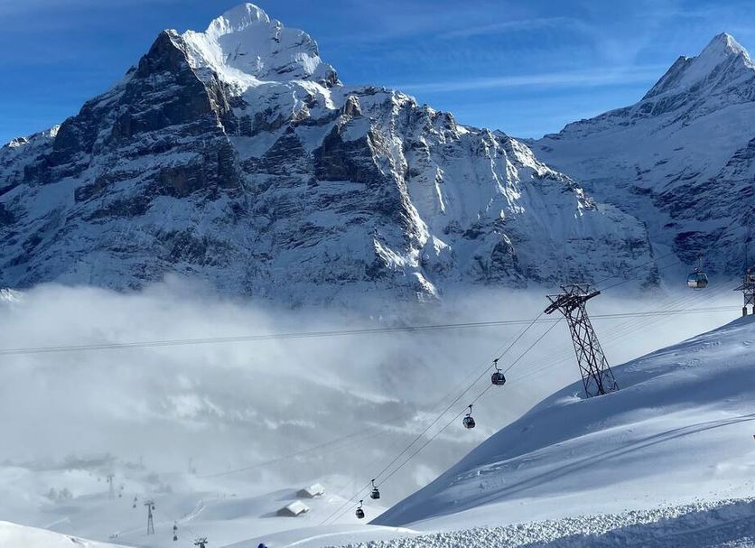 Hotel Grindelwalderhof in Grindelwald with snowy Alps and a cable car over the mountain slope