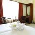 Fabhotel Prime Chennai Deluxe room with twin beds, TV, chairs and large window in Chennai
