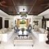 The Ungasan Clifftop Resort in South Kuta living room with white sofas, ceiling fans and tropical garden view