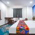 Hotel Taj Heritage in Agra room with king bed, colorful runner, chairs, TV and Taj Mahal mural