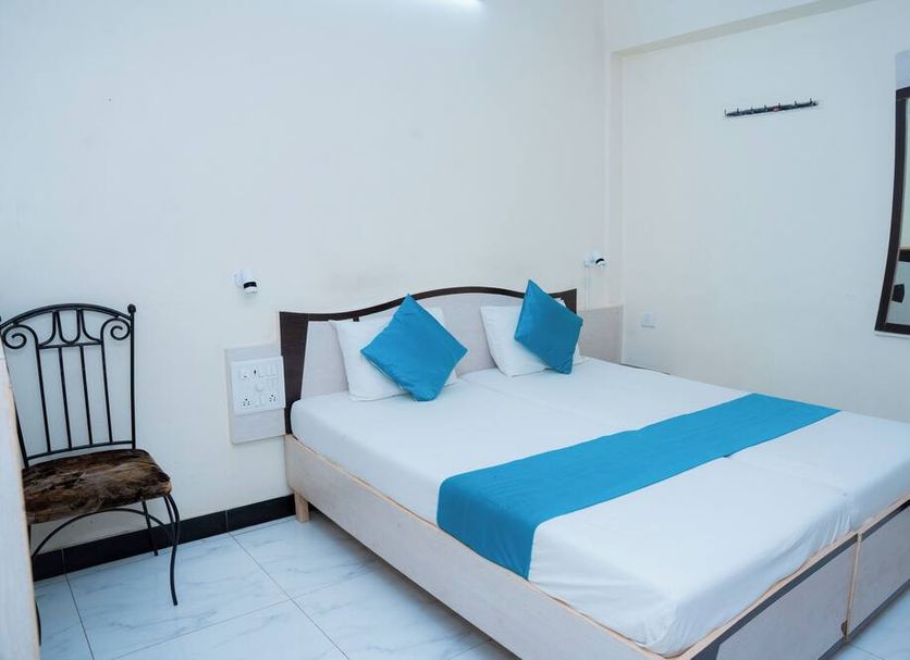 Saigal Guest House in Mumbai: simple guest room with white bed and blue accents