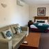 Armidale Pines Motel in Armidale: guest room with bed, sofa, coffee table and wall mirror