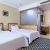 Long Ge Hotel in Beijing guest room with two twin beds and patterned carpet