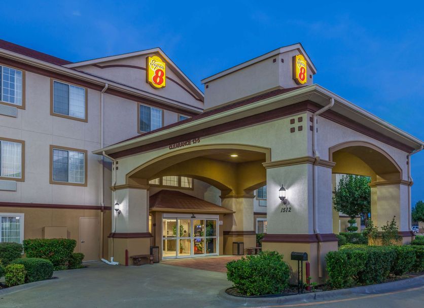 Super 8 by Wyndham Hillsboro TX exterior with covered entrance at dusk in Hillsboro