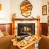 Rendezvous Mendocino in Gualala: cozy lounge with fireplace, armchairs, and breakfast tray by the window
