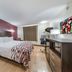 Red Roof Inn & Suites Denton guest room with king bed, desk, and kitchenette area