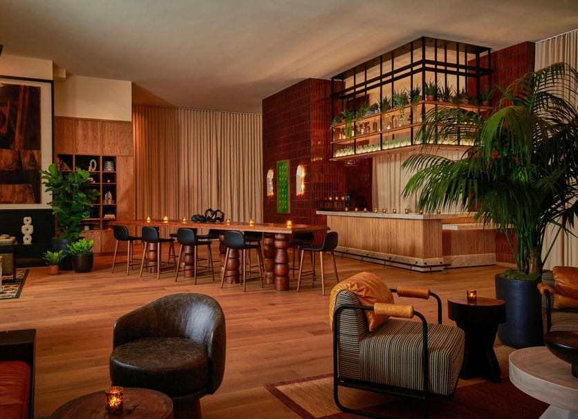 Lobby lounge at HOLLYWOOD VOLUME, a Tribute Portfolio Hotel in Los Angeles with bar seating and warm wood decor
