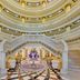 Kempinski Hotel Palm Jumeirah Dubai grand lobby with twin curved staircases and ornate chandelier ceiling