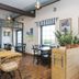 Kurort Stara Wedzarnia in Gdansk dining area with wicker chairs, wooden tables, and potted plants by the window.