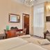 Sun Palace Wellness Hotel in Mariánské Lázně guest room with bed, seating area, desk and wall-mounted TV