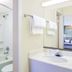 Super 8 by Wyndham Ashland/Richmond bathroom with bathtub, sink, mirror, and towel rack