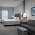 Home2 Suites by Hilton Lake City guest room with bed, sofa, desk and TV