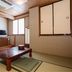 Hotel Ikedaya Matsumoto tatami room with low table, window, and sliding closet doors
