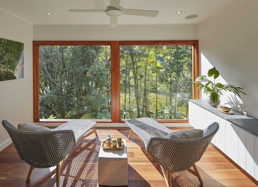 Silky Oaks Lodge in Mossman lounge with wicker chairs and forest views through large windows
