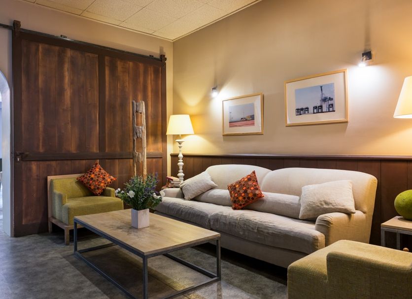 Hôtel Edmond Rostand Marseille lounge with sofa, coffee table, lamps and wood sliding door