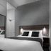 Qudos Salisbury hotel room with double bed, wall mirror, and bedside lights