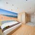 Super 8 by Wyndham Qingdao Jiaonan Heng Li Yuan room with beach mural and wall-mounted TV in Qingdao