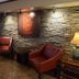 Red Roof Inn & Suites Cornelius - Lake Norman lobby seating area with stone wall, leather chairs and lamp