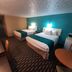 Howard Johnson by Wyndham Woodstock NB room with two beds and teal accent wall in Woodstock