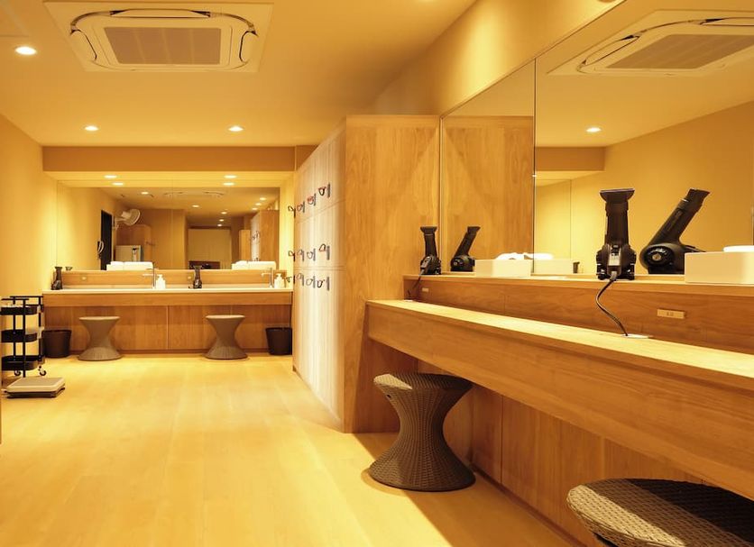 Sanso Kaze No Mori in Minoh: warm wood vanity area with mirrors and stools