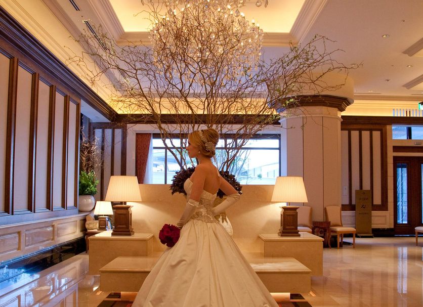 Bride in a ballroom lobby at Hotel La Suite Kobe Harborland, Kobe, beneath a crystal chandelier