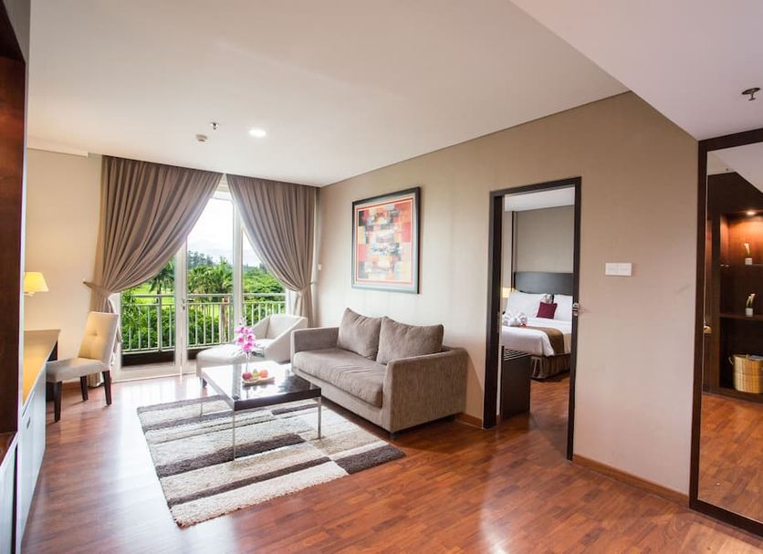 The Royale Krakatau in Serang City hotel suite with sofa, coffee table, and balcony view