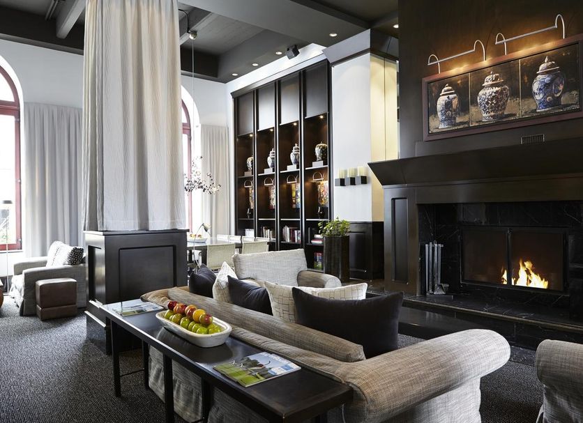 Le Germain Hotel Quebec lounge in Québec City with fireplace, seating area, and arched windows