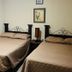 Hostal Los Volcanes in Guatemala City room with two double beds and wall art