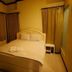 Bangrak Resort in Nakhon Sawan guest room with queen bed, bedside table, and curtained windows