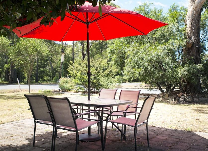 Gariwerd Motel Halls Gap outdoor patio with red umbrella and seating among trees