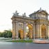 Hospes Puerta de Alcalá in Madrid with the illuminated Puerta de Alcalá landmark at dusk
