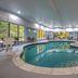 Indoor pool at Holiday Inn Express & Suites Zanesville North in Zanesville with large windows and lounge chairs