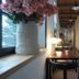 Turn Hostel Ljubljana hallway lounge with wooden tables, lamps, and flowers by a window