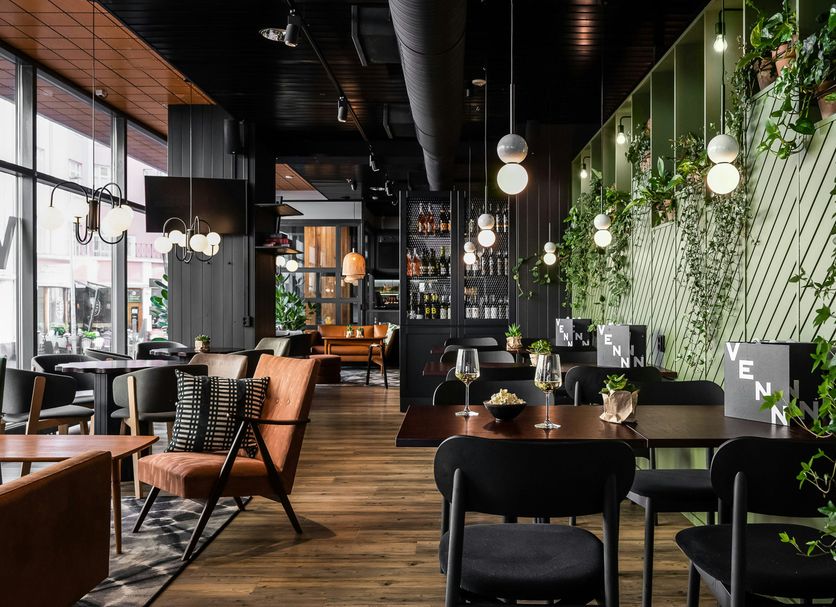 Original Sokos Hotel Arina in Oulu lounge dining area with plants, pendant lights, and wooden tables