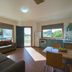 The Retreat at West Beach Parks apartment living area with kitchen, sofa, dining table and garden views
