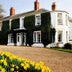 The Grove Cromer hotel exterior in Cromer, ivy-covered house with daffodils and gravel driveway