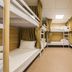 Guanwu Villa in Tai'an Township shows a shared dormitory room with bunk beds and privacy curtains.