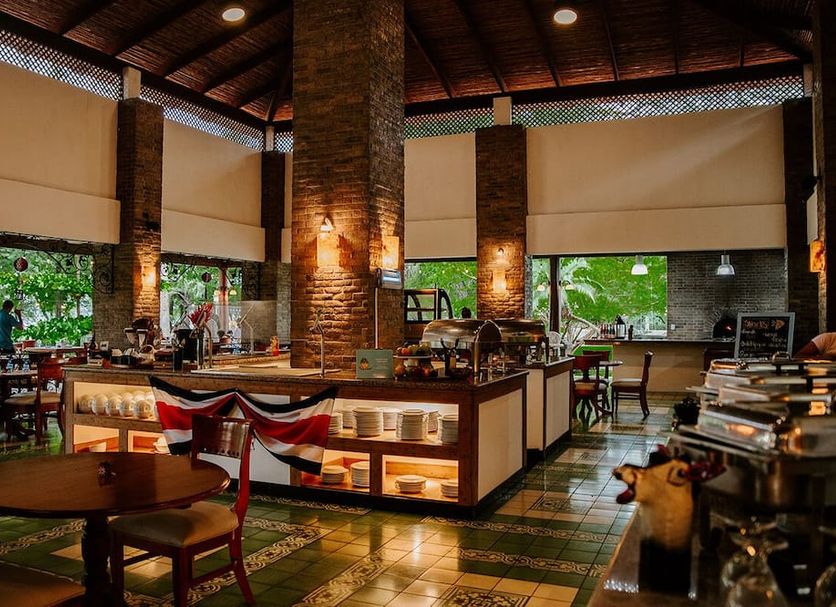 CC Beach Front Hotel in Playa Hermosa restaurant with brick pillars, buffet counter and garden views